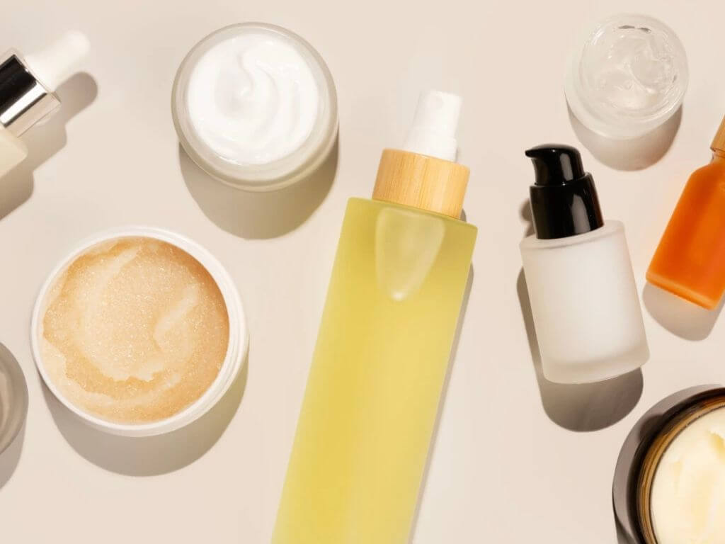 A flat lay of skincare products, including creams, serums, and oils, on a neutral background.