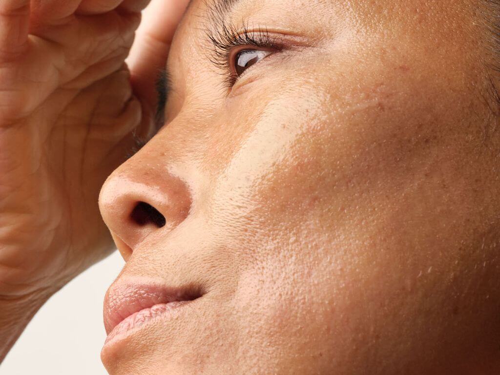 A close-up of a woman’s radiant, natural skin with a focus on her smooth complexion.